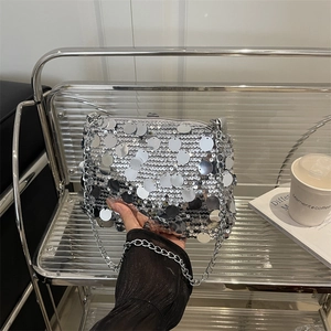Bolso bandolera chic de lentejuelas plateadas con cadena en un entorno moderno