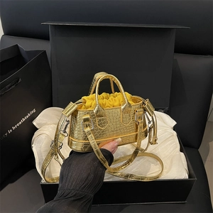Gold mini croc-embossed handbag with drawstring pouch presented in a black luxury gift box