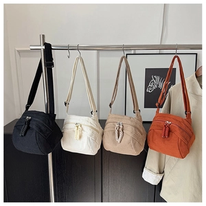 Detail of four corduroy crossbody bags in black, white, beige and caramel colors