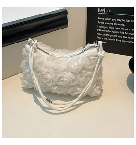 Detailed macro view of 3D white rose fabric texture and silver zipper on handbag