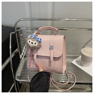 Detailed view of pink vintage handbag with embossed bears and soft plush charm