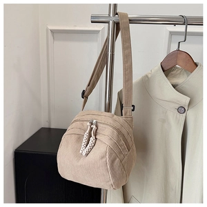 Dettaglio della borsa a conchiglia in velluto a coste beige con doppia zip