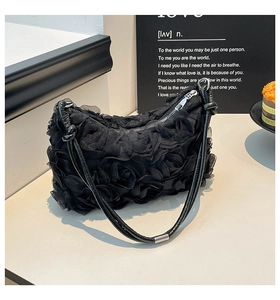 Detail of 3D rose mesh fabric and silver metal zipper on a black shoulder bag