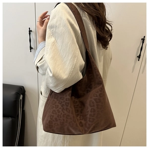 Side view of large leopard print tote bag worn by a model for a casual autumn look