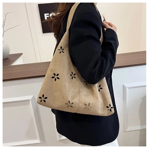 Detail of khaki suede tote bag with laser-cut hollow flower patterns and minimalist texture