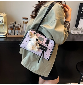 Detail of light purple polka dot shoulder bag with cute plush puppy charm and zip pocket