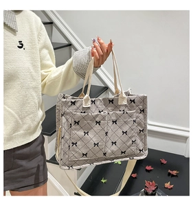Detail of corduroy tote bag featuring bow patterns and large front pockets for storage