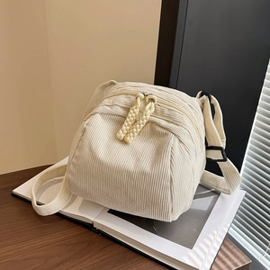 Beige corduroy shell bag for women with woven zipper detail and adjustable strap