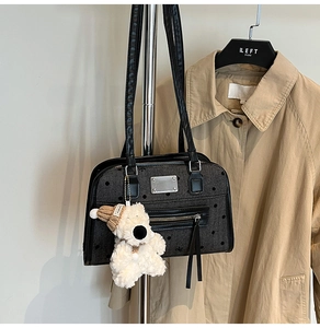 Close-up of a large capacity grey polka dot shoulder bag with cute plush bear charm