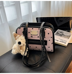 Detailed view of pink polka dot shoulder bag with cute bear charm and laptop