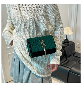 Green velvet chain crossbody bag with V-shaped stitching and golden tassel detail