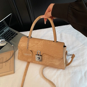 Chic earthy brown flap handbag with silver buckle and shoulder strap in office setting
