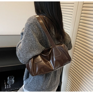Detail view of the dark brown glossy leather shoulder bag with elegant pleated texture