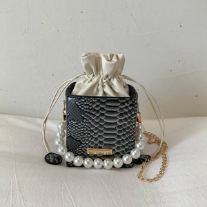 Detail of snake pattern bucket bag with pearl handle and golden chain strap