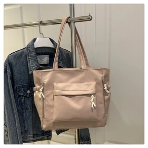 Macro detail of spacious light pink tote bag featuring functional side zipper pockets