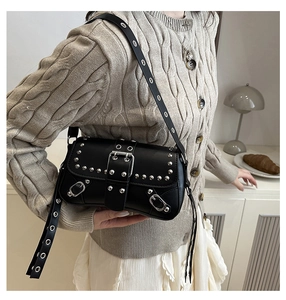 Detail showing Y2K punk style black leather bag with metallic silver studs and buckles