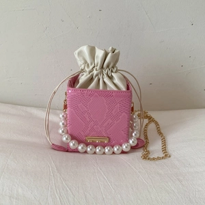 Detail of pink snake pattern mini bucket bag with pearl handle and drawstring closure