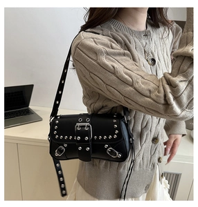 Detail of silver rivets and buckle on black punk style leather shoulder bag