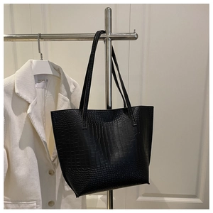 Detail of black crocodile texture on a large capacity PU leather tote bag with shoulder straps