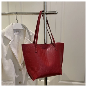 Detail of red crocodile pattern tote bag with dual handles for daily commute use
