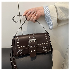 Detail of vintage coffee shoulder bag with silver punk studs and metal eyelet accents
