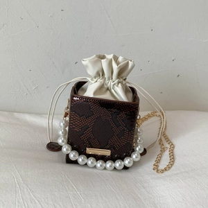 Detail of dark brown snakeskin bucket bag with pearl handle and drawstring inner lining
