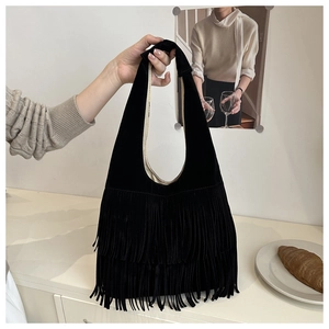 Close-up of black fringe hobo bag with suede texture in a cozy lifestyle setting