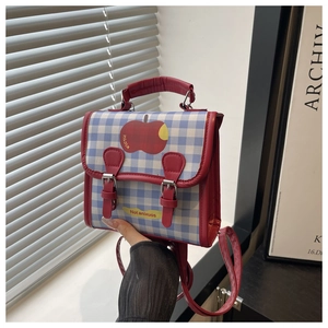 Close-up of checkered mini backpack featuring cute apple print and vintage red buckles