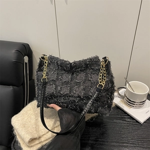 Sac rétro noir à carreaux avec texture frangée et bandoulière en chaîne dorée