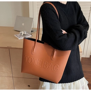 Brown leather tote bag featuring TOTE BAG embossed design and slim dual shoulder straps