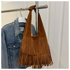 Detail of brown suede tassel shoulder bag showing long fringes and knotted strap detail