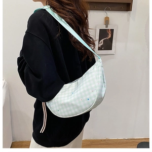 Detail of light green plaid dumpling bag with small colorful star patterns for girls