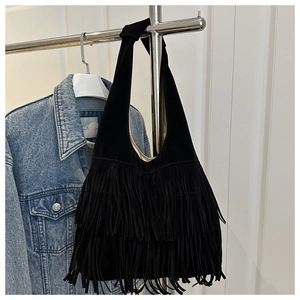 Detail shot of black hobo bag featuring dense long tassels and soft matte suede texture