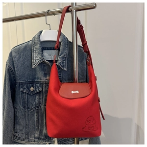 Detail of red crescent tote bag with metal bone clasp and cartoon dog embossing