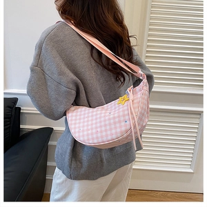 Detail of pink plaid crescent bag with star prints and yellow star charm accessory