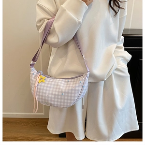 Detail of light purple checkered crescent bag with star charms on a white sweatshirt