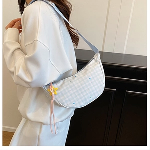 Plaid crescent shoulder bag with star charms worn as a cross-body on a model