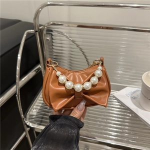 Brown bow-shaped mini handbag with decorative white pearls and golden hardware