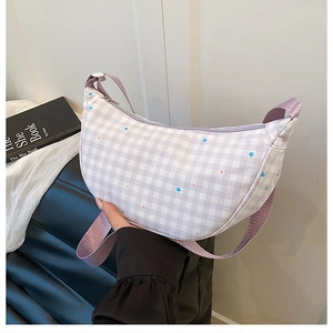 Detail of light purple checkered crescent bag with colorful star prints and purple strap