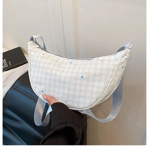 Detail of light blue checkered crescent bag with star prints and adjustable strap