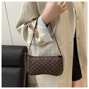 Detail of vintage brown shoulder bag with M-pattern jacquard and fashion tag