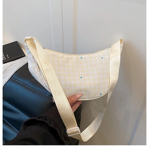 Detail of checkered crescent bag with star prints and adjustable cream shoulder strap