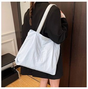 Detail of light blue tote bag with wrinkled texture fabric and Tide Coco brand label