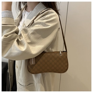 Close-up of retro brown shoulder bag with monogram M pattern and fashion hangtag