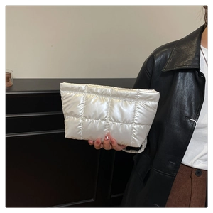Détail d'une pochette matelassée argentée avec finition brillante et rembourrage doux