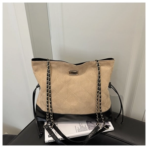 Detail of two-tone quilted tote bag with gold chain strap and drawstring sides