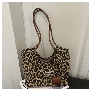 Detail of leopard print suede tote with dark brown leather handles and small pouch