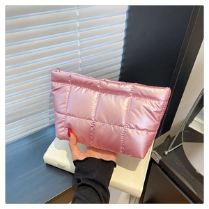Pochette matelassée rose au fini métallisé avec fermeture éclair dorée sur livres