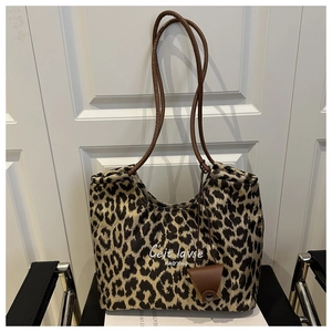 Dettaglio borsa shopper leopardata con manici in similpelle marrone e astuccio
