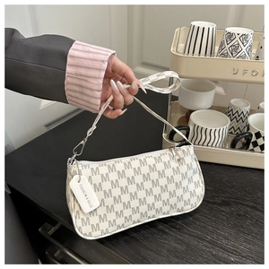 Detail of cream white underarm bag with M-letter monogram print and silver zipper